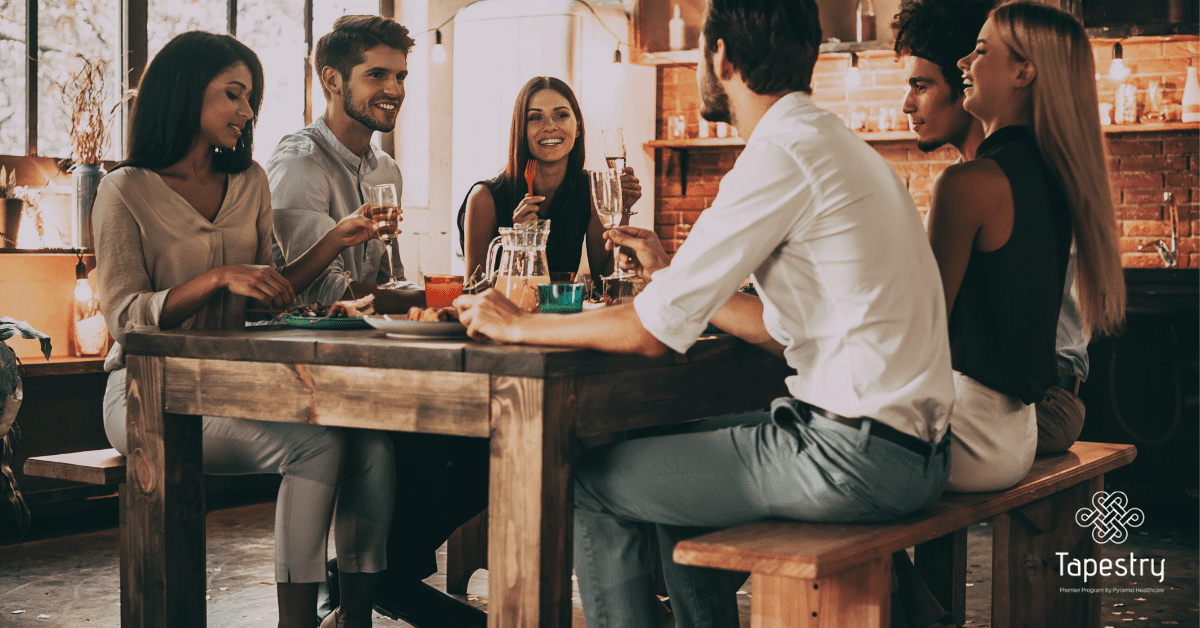 Group of friends sitting around enjoying a meal together