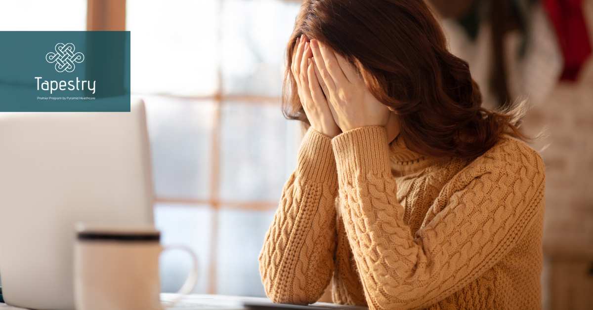 Adult woman sitting at a table in distress