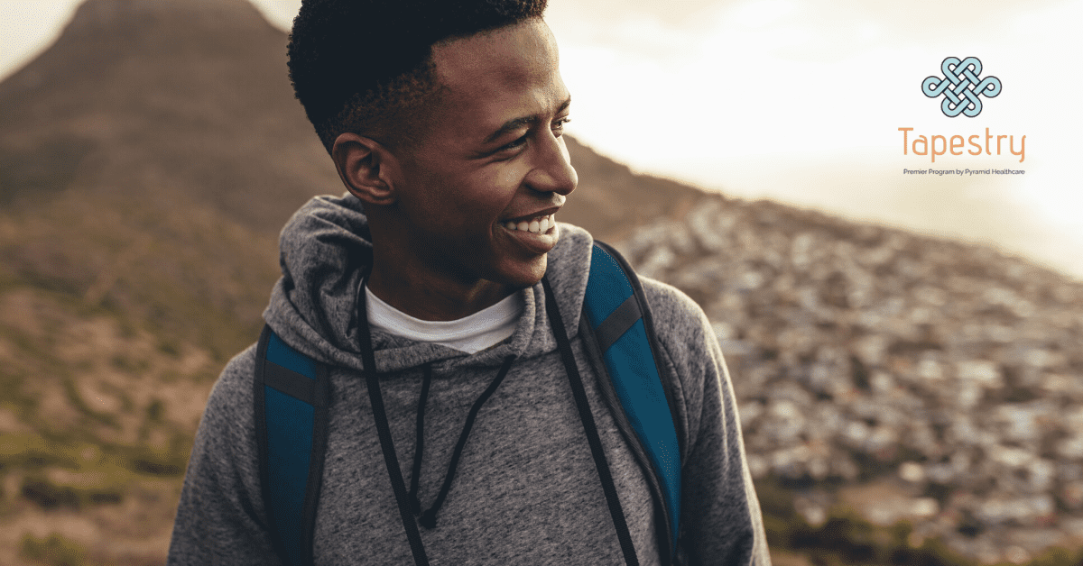 Young African American male on a hike looking out and smiling