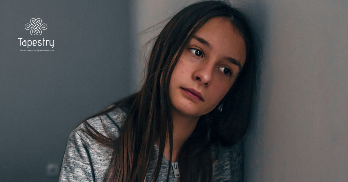 Young girl leaned against the wall, upset