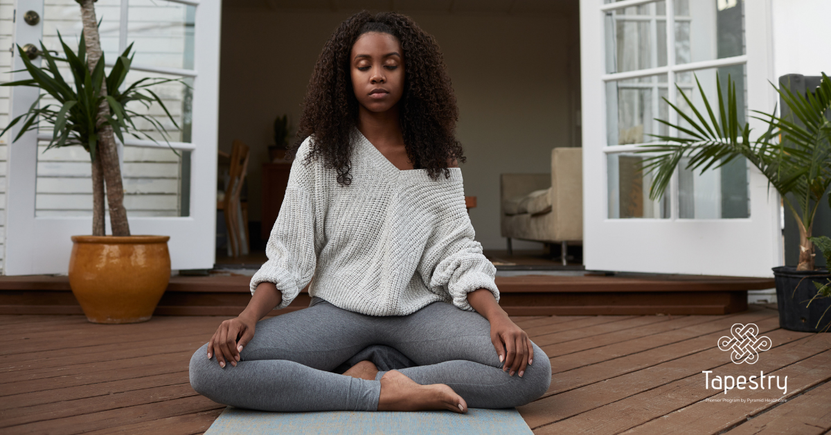 African American woman practicing yoga on her deck