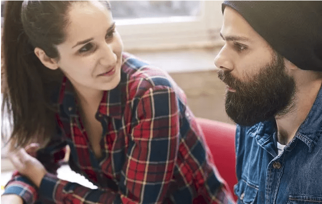 Young adult man and woman having a conversation on the couch