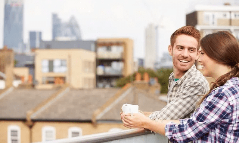 Young couple on a rooftop balcony having a conversation