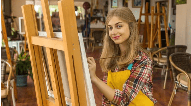 Young adult woman painting