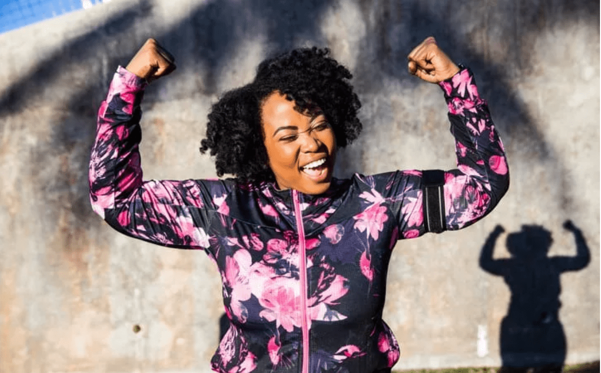 African American woman flexing and smiling after a walk