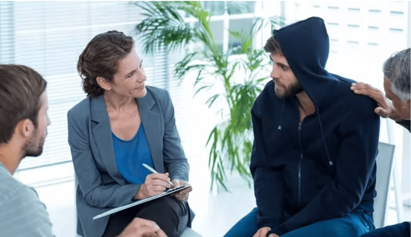 Adult man being consoled during a group therapy session