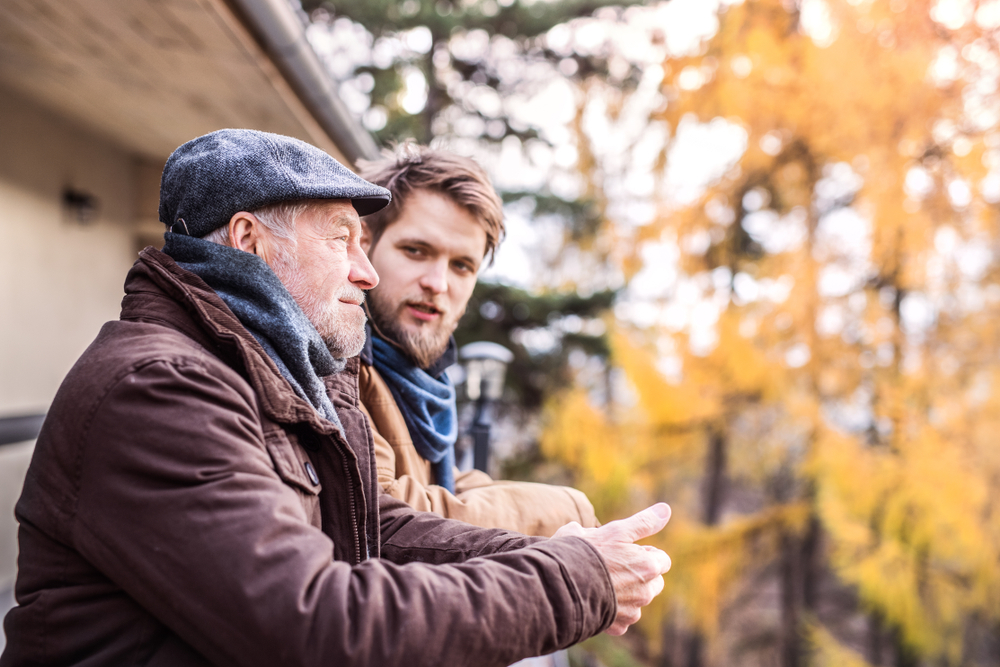 Father and son standing on a deck having a conversation