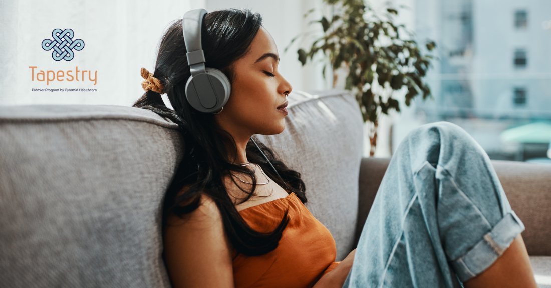 Woman listening to music with her eyes closed while on the couch