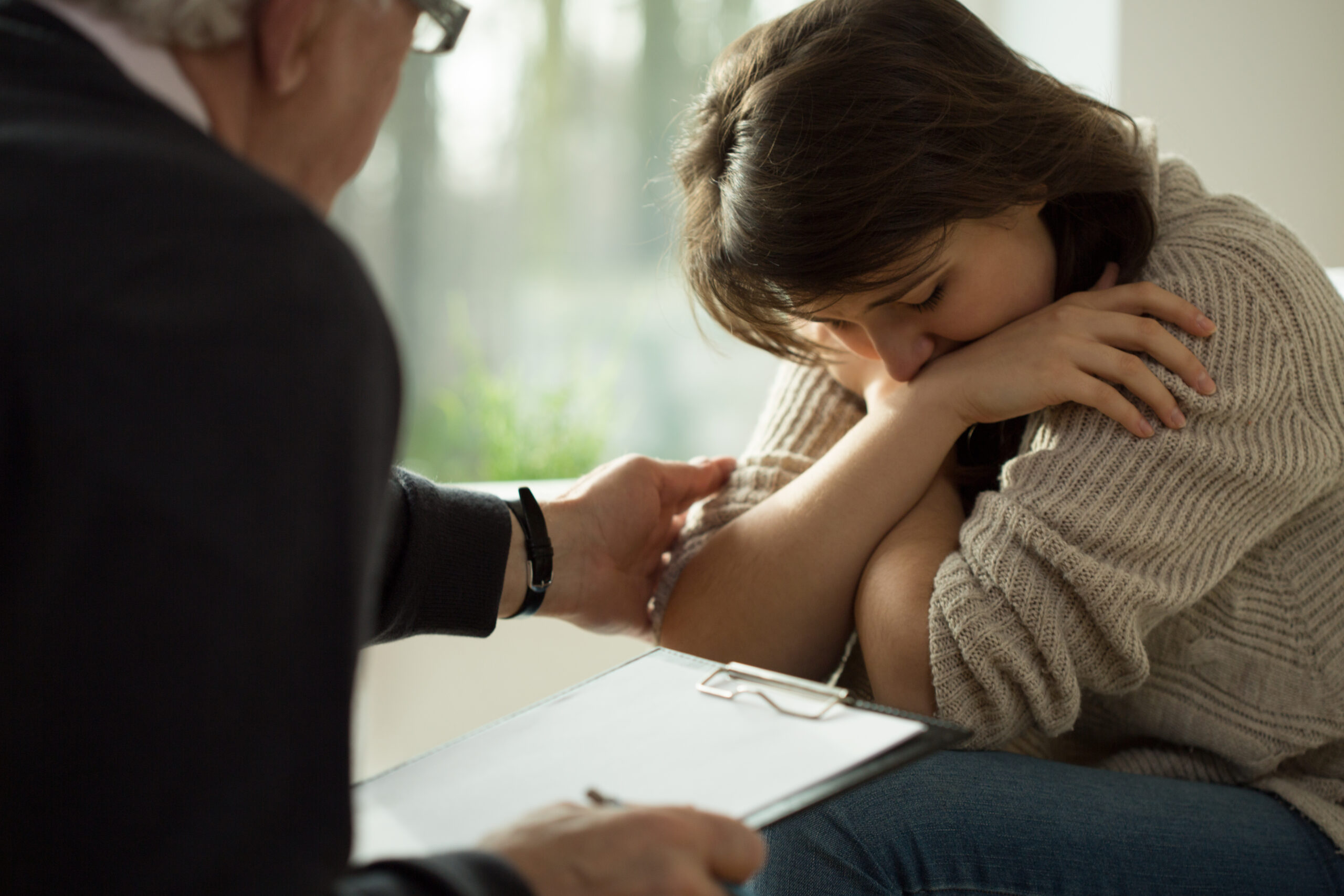 Psychologist comforting his depressed patient