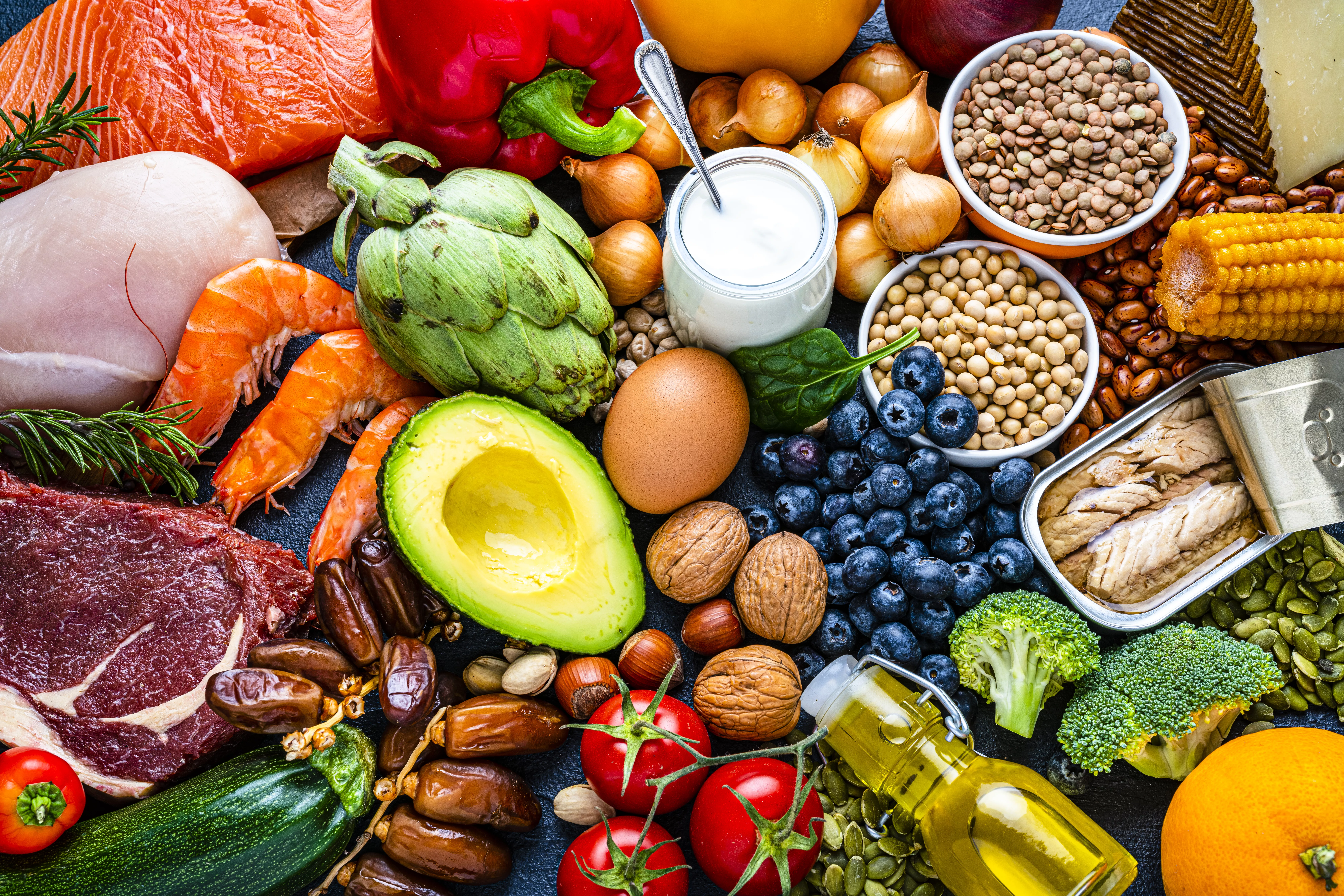 Overhead view of a large group of healthy raw food for flexitarian mediterranean diet. The composition includes salmon, chicken breast, canned tuna, cow steak,  fruits, vegetables, nuts, seeds, dairi products, olive oil, eggs and legumes. High resolution 42Mp studio digital capture taken with SONY A7rII and Zeiss Batis 40mm F2.0 CF lens